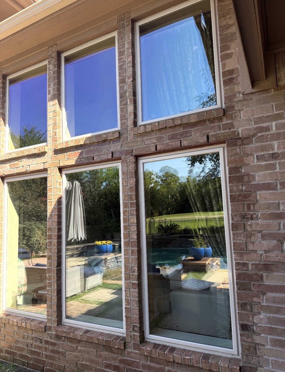 Professional cleaning crew washing exterior windows of a modern Texas home
